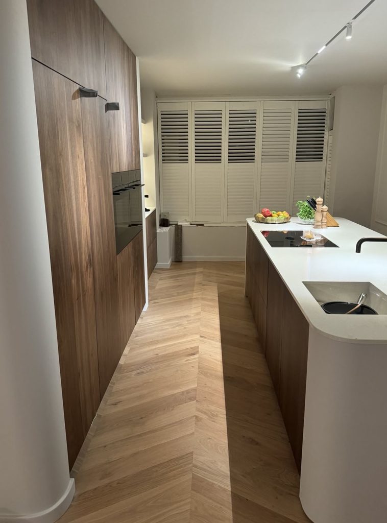 Kitchen with wooden paneling and smooth, rounded white finishes